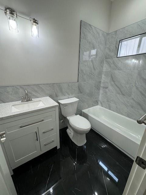 full bathroom featuring tiled shower / bath, vanity, tile walls, and toilet