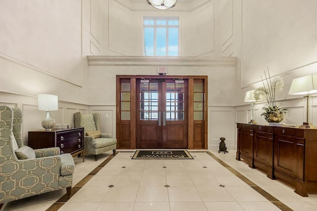 tiled entryway with a towering ceiling and french doors