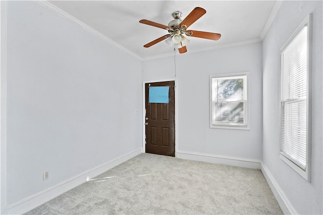 carpeted empty room featuring ceiling fan and crown molding