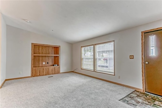 interior space featuring carpet floors and vaulted ceiling