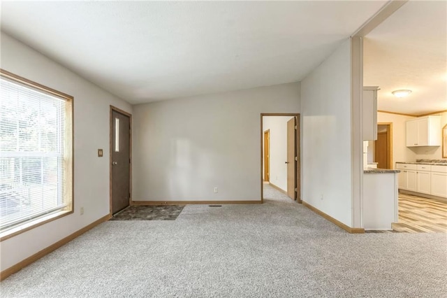 unfurnished living room with light colored carpet and lofted ceiling