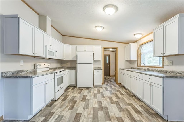 kitchen featuring white cabinets and white appliances