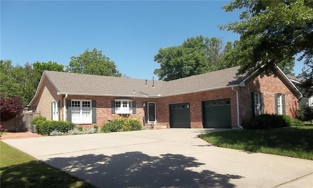 ranch-style home with a garage, brick siding, driveway, a shingled roof, and a front yard