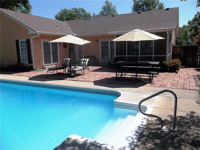 view of swimming pool featuring a patio and fence