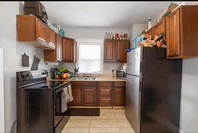 kitchen featuring light tile patterned flooring, appliances with stainless steel finishes, and sink