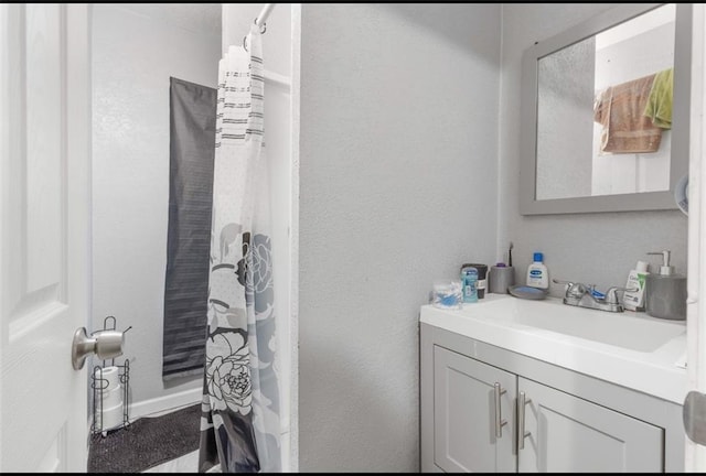 bathroom featuring walk in shower and vanity