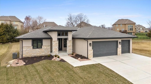 view of front of house featuring central AC unit, a garage, and a front lawn