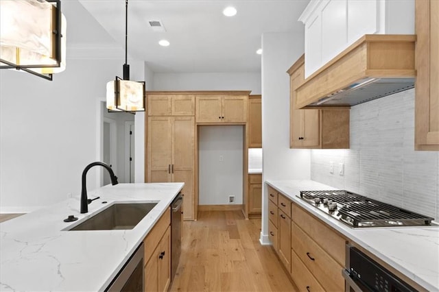 kitchen with appliances with stainless steel finishes, decorative light fixtures, light stone counters, and sink