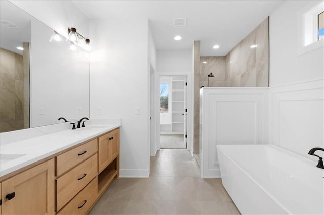 bathroom featuring plus walk in shower, vanity, and tile patterned floors