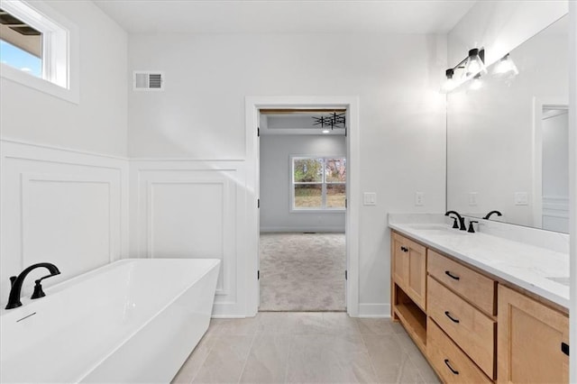 bathroom featuring vanity, tile patterned floors, plenty of natural light, and a tub