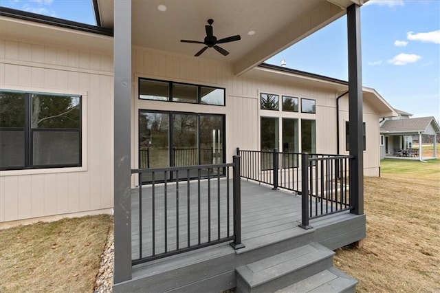 wooden terrace with ceiling fan and a yard