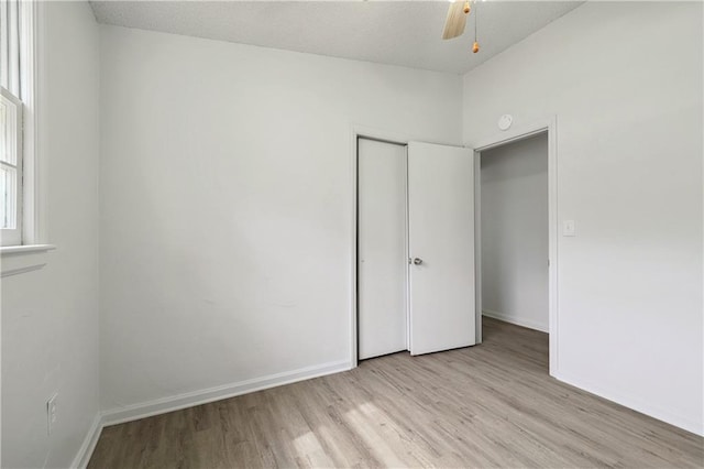 unfurnished bedroom featuring light hardwood / wood-style floors, ceiling fan, and a closet