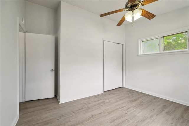 unfurnished bedroom featuring light hardwood / wood-style floors, ceiling fan, and a closet