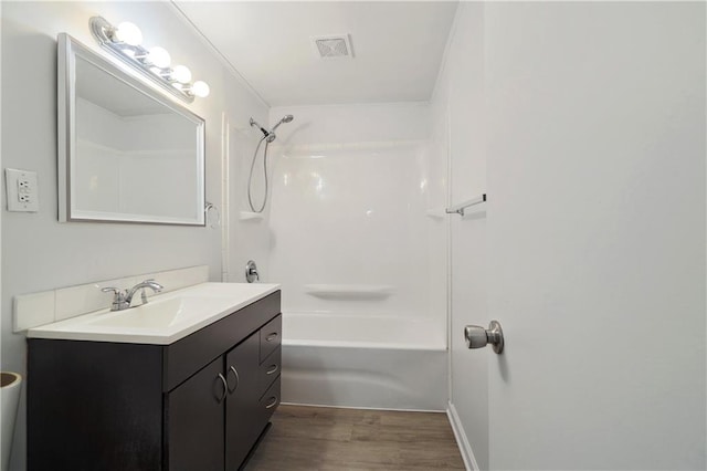 bathroom with tub / shower combination, vanity, and hardwood / wood-style floors