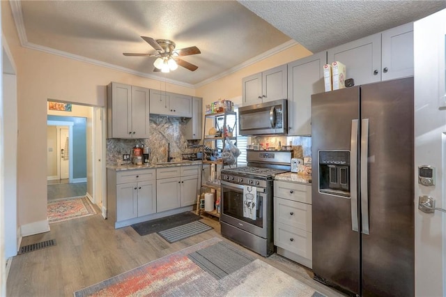 kitchen featuring sink, light stone countertops, light hardwood / wood-style flooring, and stainless steel appliances