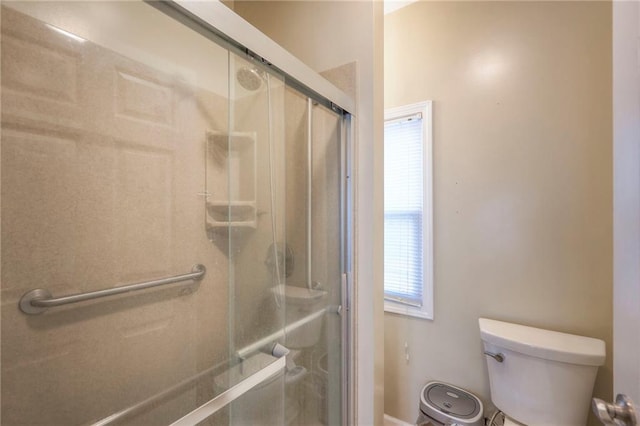 bathroom with toilet and a shower with shower door