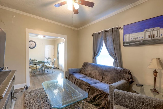 living room featuring crown molding, light wood-type flooring, and ceiling fan