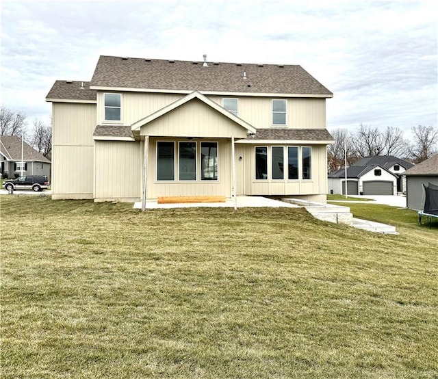 rear view of house featuring a patio, a lawn, and a trampoline