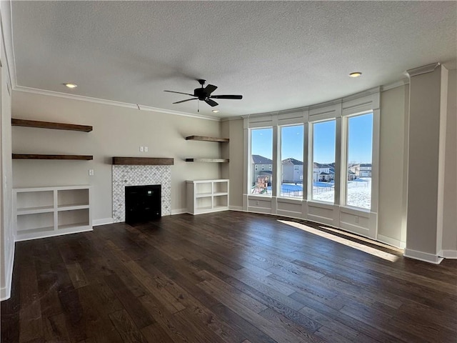 unfurnished living room with built in shelves, a textured ceiling, ceiling fan, and a tile fireplace