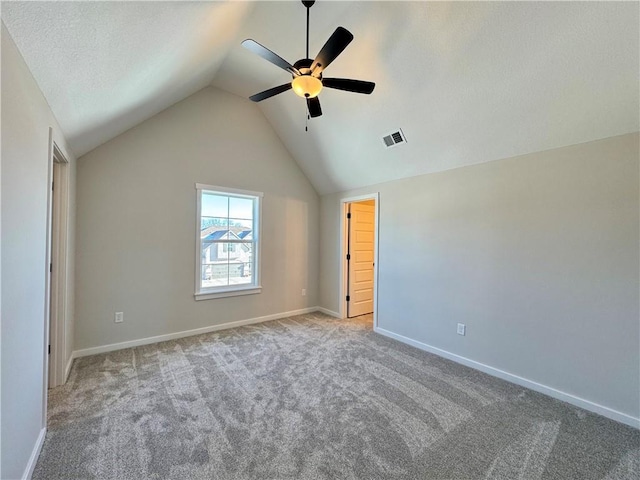 unfurnished room with ceiling fan, light carpet, and vaulted ceiling