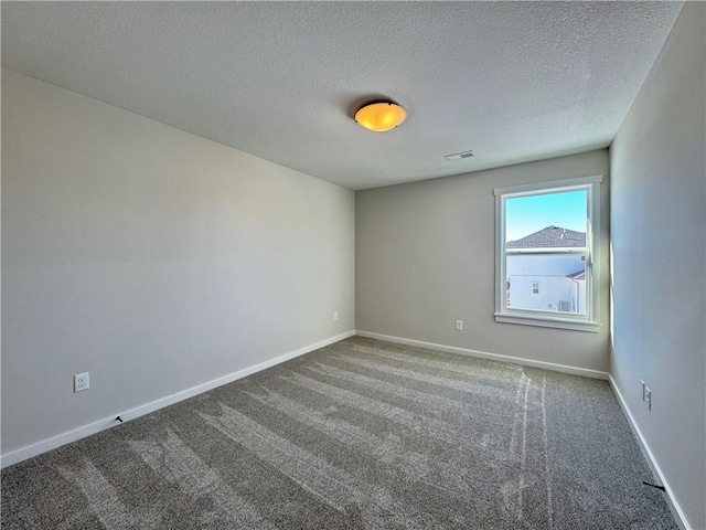 carpeted spare room with a textured ceiling