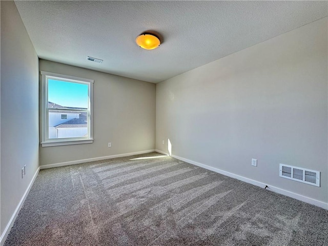 carpeted spare room featuring a textured ceiling