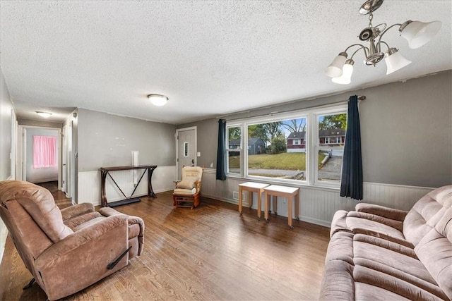 living room featuring a notable chandelier, a textured ceiling, and dark hardwood / wood-style flooring