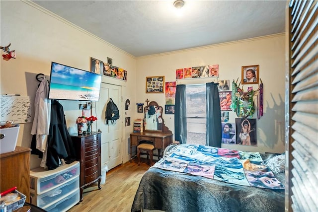 bedroom with light hardwood / wood-style flooring and ornamental molding