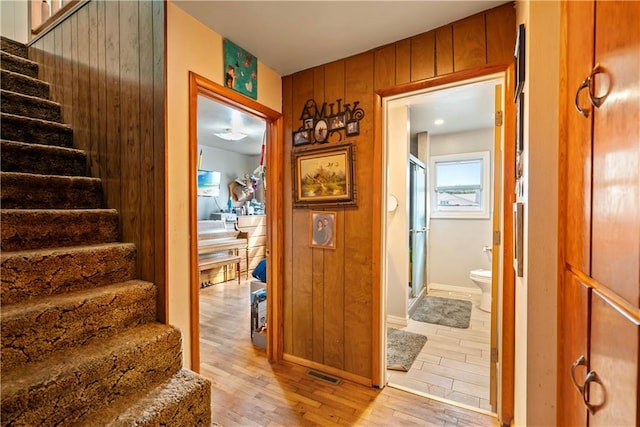 stairway with wood-type flooring and wood walls