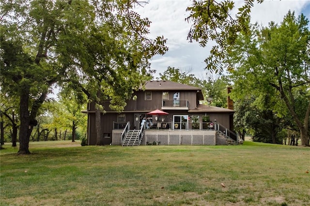 rear view of house featuring a deck and a yard