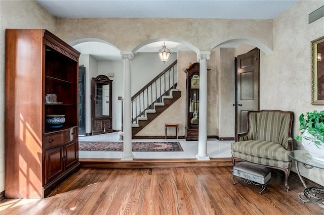 foyer with decorative columns and hardwood / wood-style floors