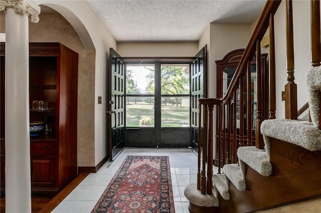 foyer with a textured ceiling and light tile patterned floors