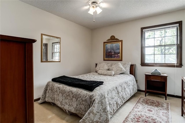 carpeted bedroom featuring a textured ceiling and ceiling fan