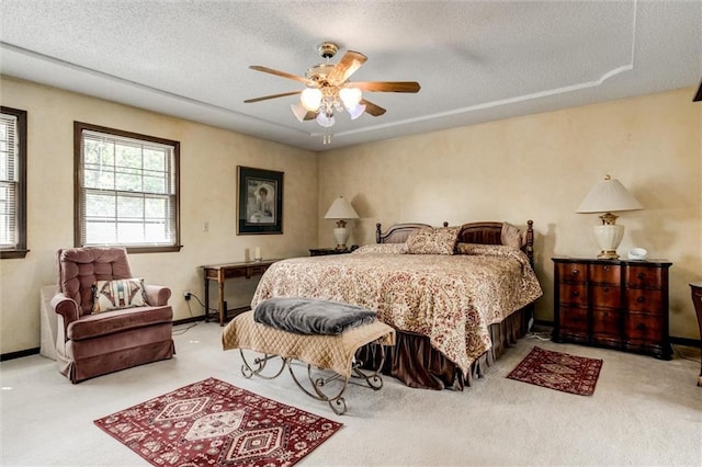 carpeted bedroom with ceiling fan and a textured ceiling