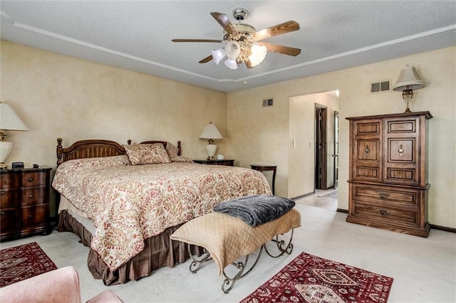 carpeted bedroom with ceiling fan and a textured ceiling