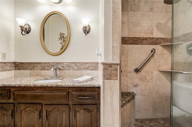 bathroom with tile walls, vanity, and a shower with shower door