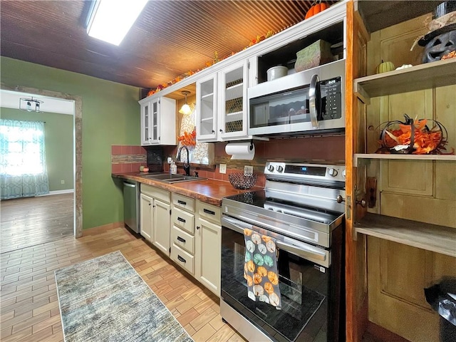 kitchen featuring light hardwood / wood-style flooring, sink, stainless steel appliances, and white cabinets