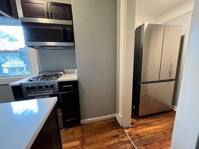 kitchen featuring stainless steel appliances and dark hardwood / wood-style flooring