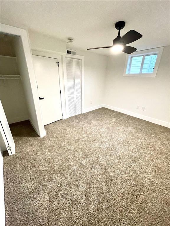 unfurnished bedroom with carpet floors and ceiling fan