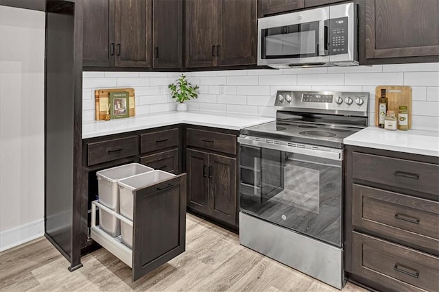 kitchen featuring dark brown cabinetry, light wood-type flooring, backsplash, and appliances with stainless steel finishes