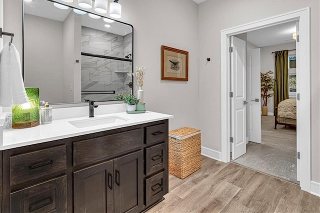 bathroom with wood-type flooring, vanity, and an enclosed shower