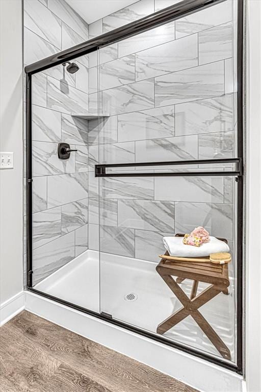 bathroom featuring wood-type flooring and a shower with door