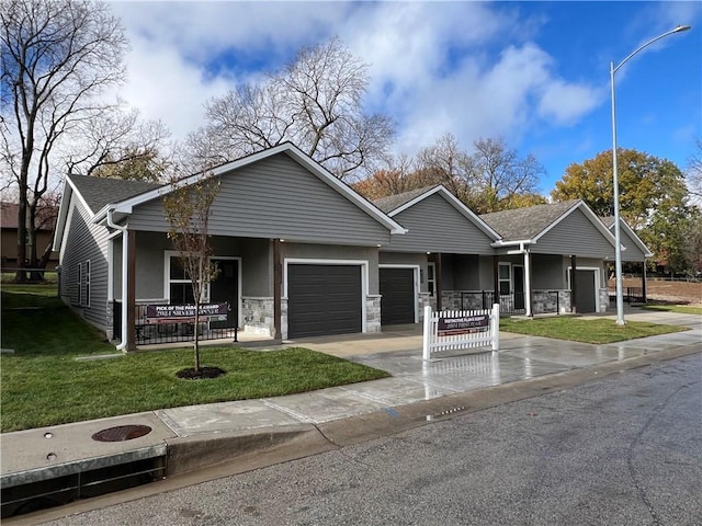 view of front of property with covered porch, a garage, and a front lawn