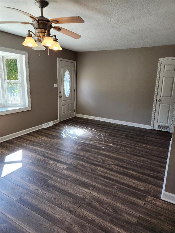 entryway featuring ceiling fan, a textured ceiling, and dark wood-type flooring