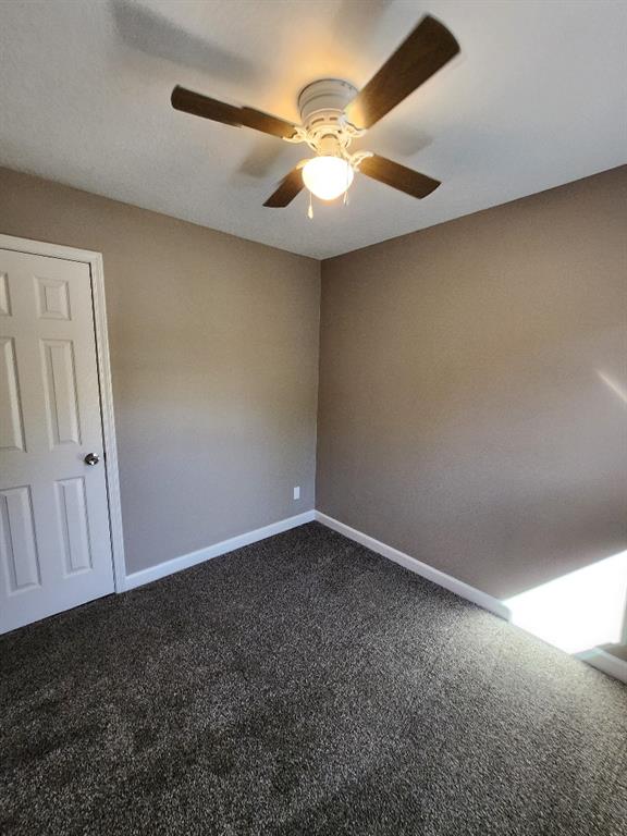 carpeted empty room with ceiling fan