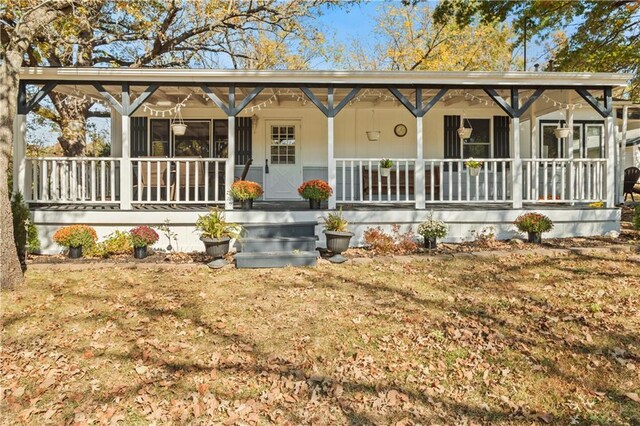 view of front of house with covered porch and a front lawn