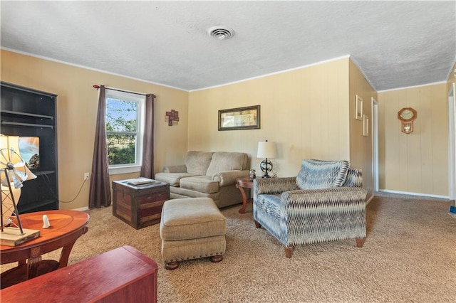 living room with a textured ceiling, carpet floors, and ornamental molding