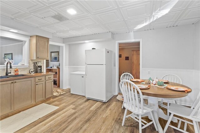 dining space featuring an ornate ceiling, wainscoting, and light wood-style flooring