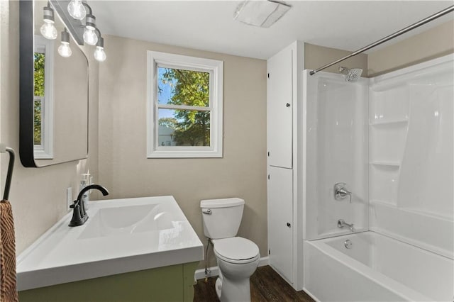 full bath with vanity, tub / shower combination, wood finished floors, toilet, and baseboards