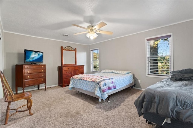 carpeted bedroom featuring ceiling fan and crown molding